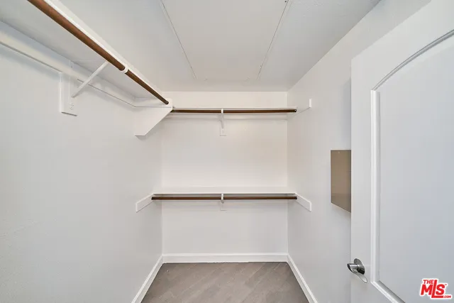 a view of walk in closet with empty racks
