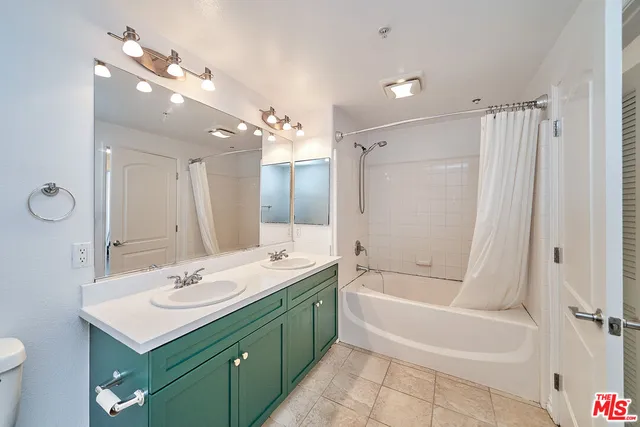 a bathroom with a sink double vanity mirror and a bathtub