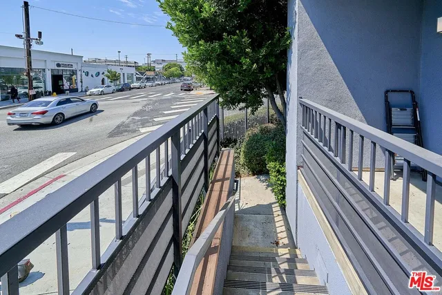 a view of a street with plants and brick walls