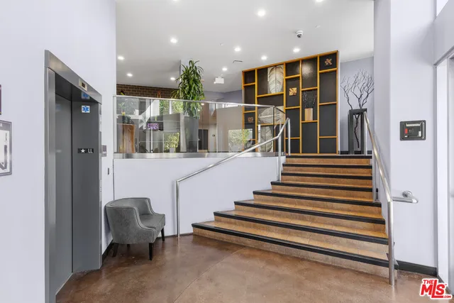 a view of a building with potted plants and sitting area