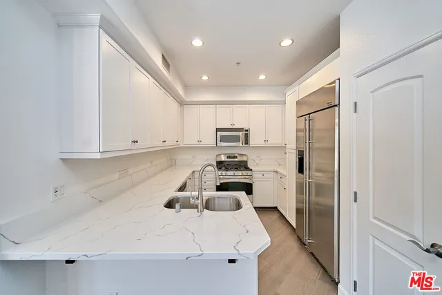 a kitchen with a sink a refrigerator and cabinets