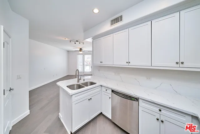 a kitchen with white cabinets and white appliances
