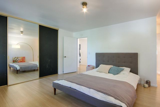 a bedroom with a bed and a view of living room