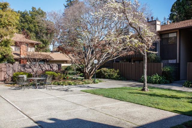a backyard of a house with barbeque oven and table and chairs