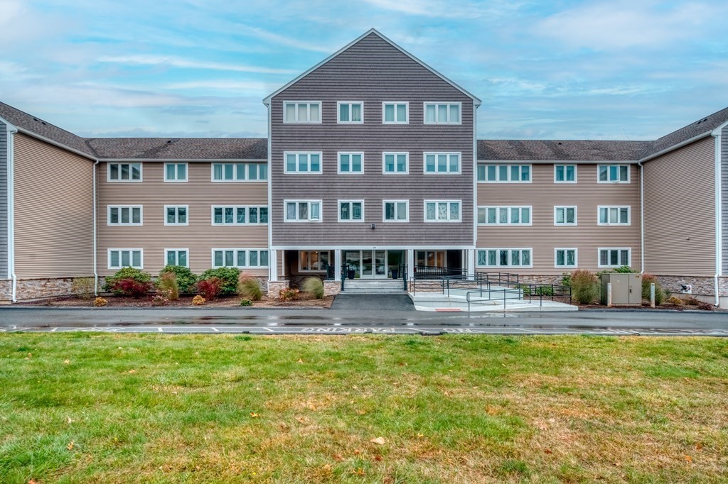 38 Dunham Road, Unit 108 Beverly, MA 01915 - Photo 1 of 30 a front view of a building with swimming pool