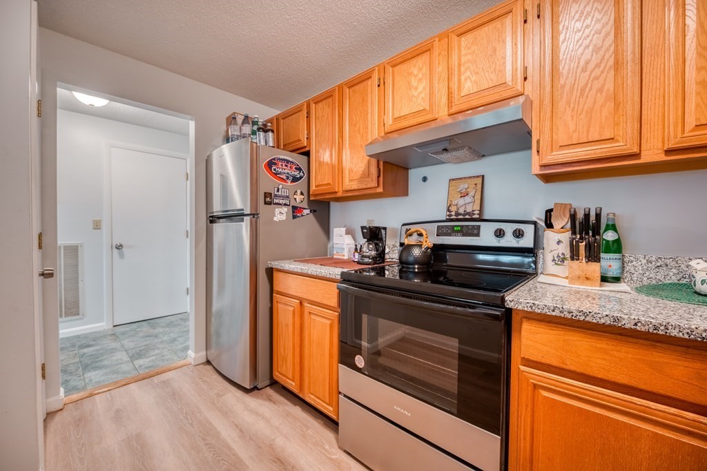 38 Dunham Road, Unit 108 Beverly, MA 01915 - Photo 11 of 30 a kitchen with stainless steel appliances granite countertop a refrigerator and a sink