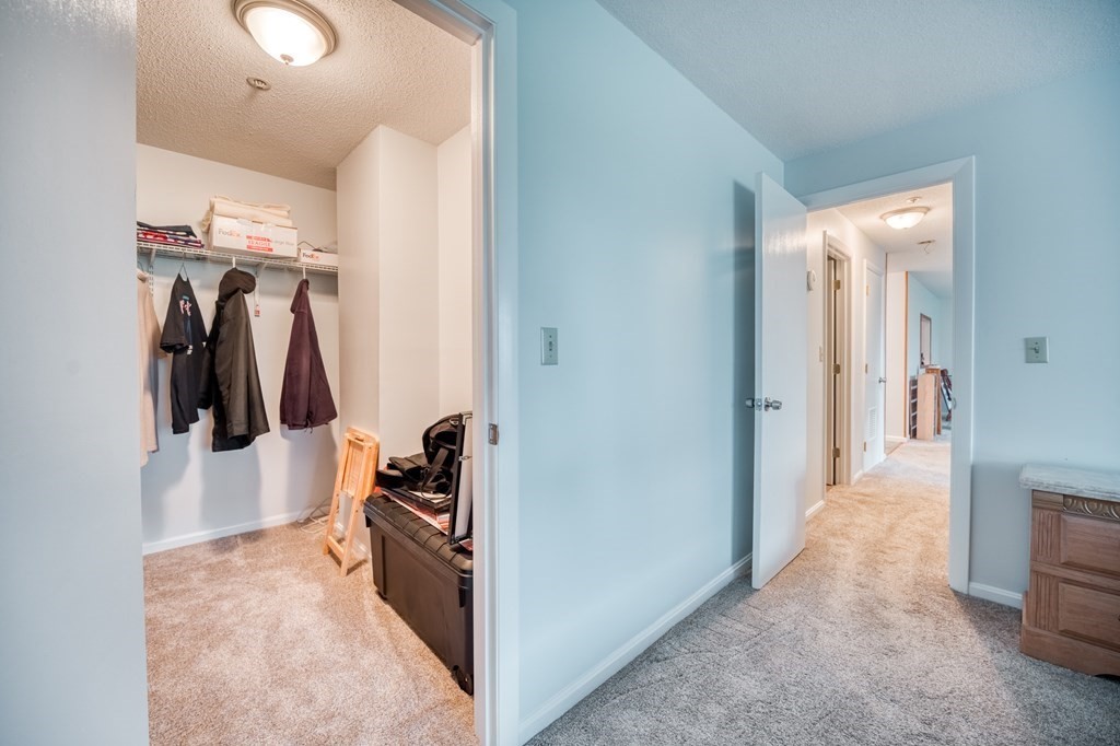 38 Dunham Road, Unit 108 Beverly, MA 01915 - Photo 14 of 30 a hallway with white walls and closet