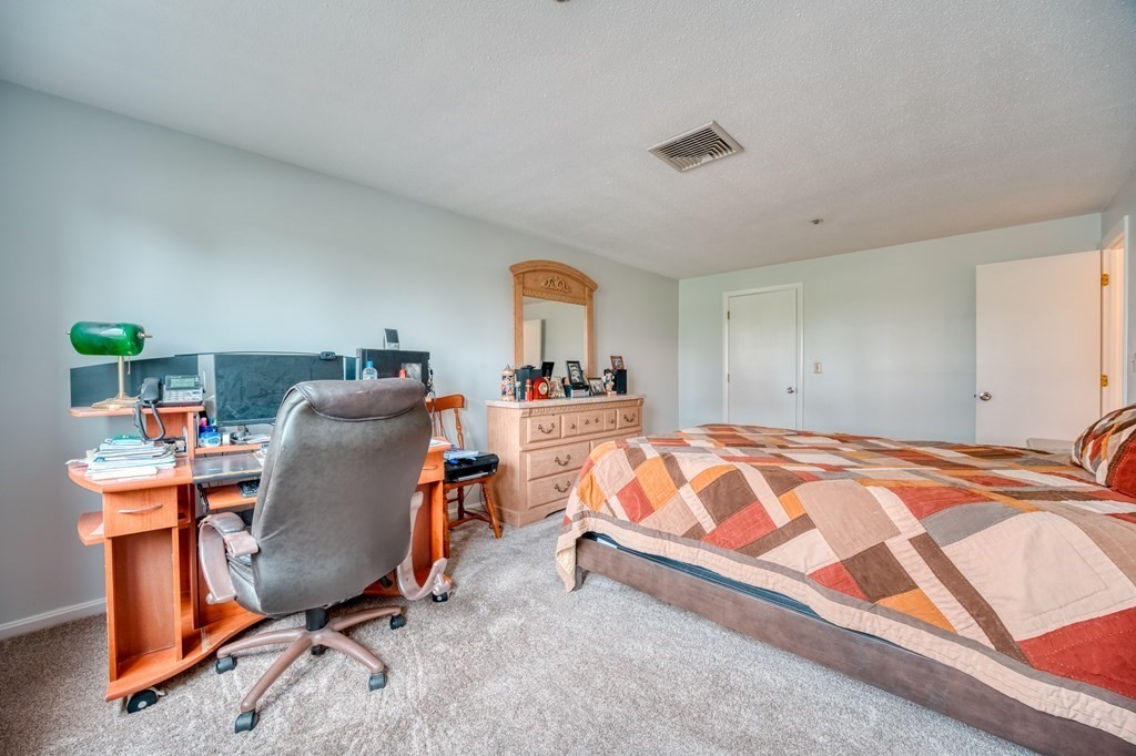 38 Dunham Road, Unit 108 Beverly, MA 01915 - Photo 18 of 30 a bedroom with bed and a furniture