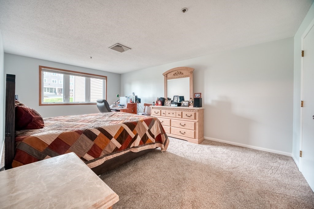 38 Dunham Road, Unit 108 Beverly, MA 01915 - Photo 19 of 30 a bedroom with a bed and window