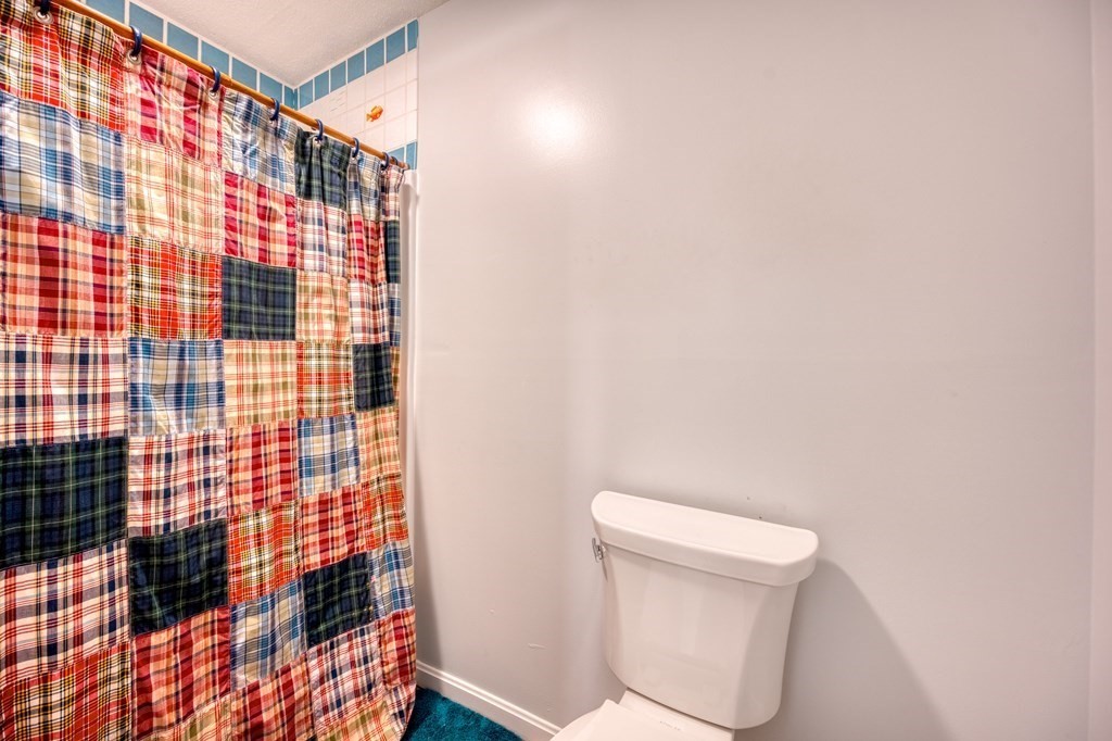 38 Dunham Road, Unit 108 Beverly, MA 01915 - Photo 21 of 30 a bathroom with a toilet and a shower curtain