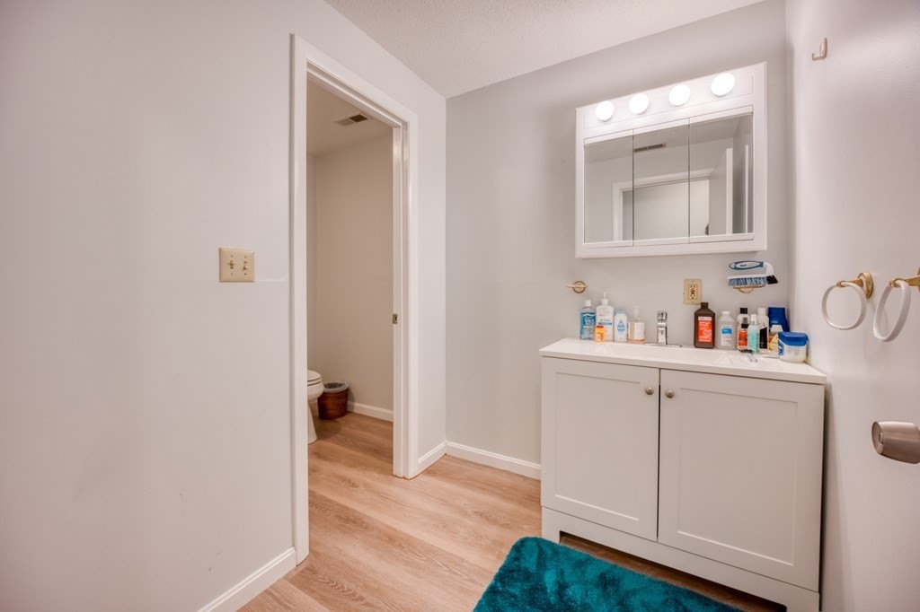 38 Dunham Road, Unit 108 Beverly, MA 01915 - Photo 22 of 30 a hallway with white cabinets and wooden floor
