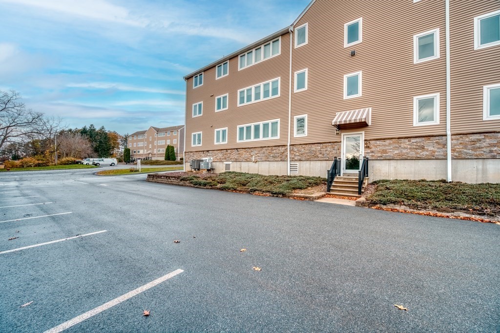 38 Dunham Road, Unit 108 Beverly, MA 01915 - Photo 27 of 30 a front view of a building with a road