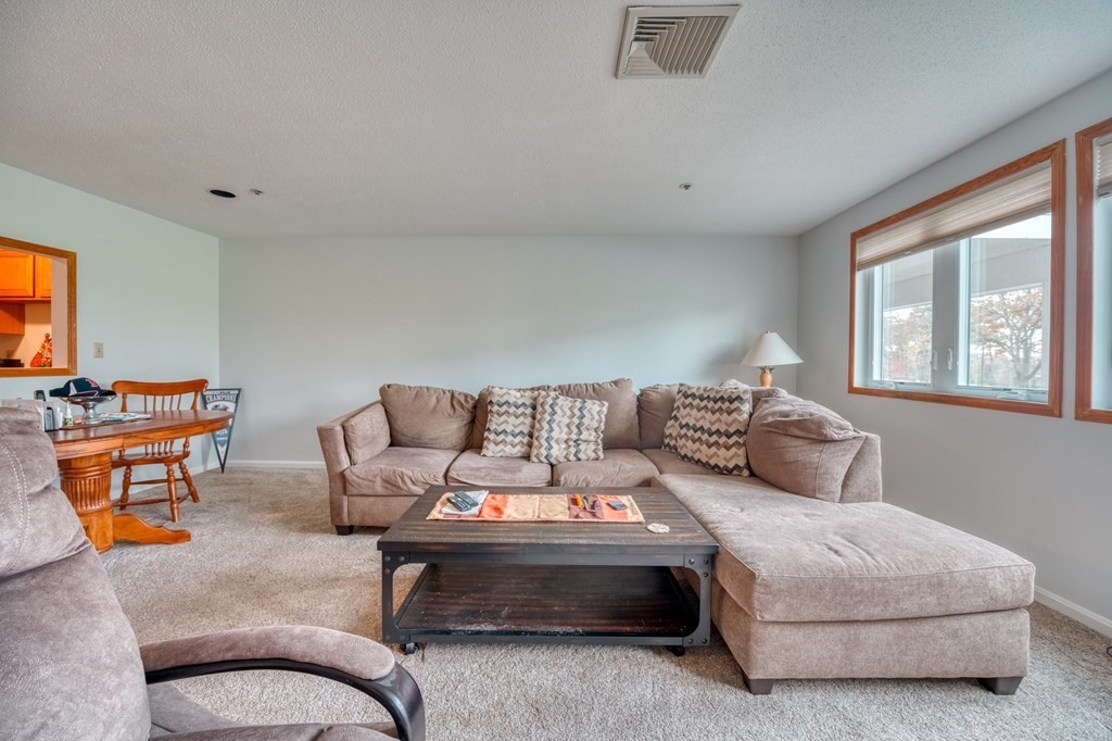 38 Dunham Road, Unit 108 Beverly, MA 01915 - Photo 3 of 30 a living room with furniture and a potted plant