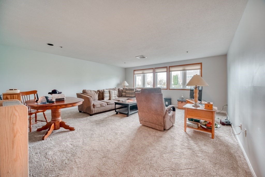 38 Dunham Road, Unit 108 Beverly, MA 01915 - Photo 5 of 30 a room with furniture and a chair