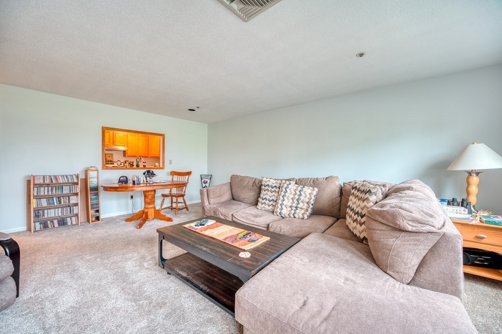 38 Dunham Road, Unit 108 Beverly, MA 01915 - Photo 6 of 30 a living room with furniture and a flat screen tv