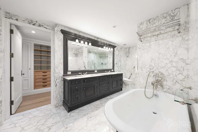 a spacious bedroom with a bed a mirror and furniture