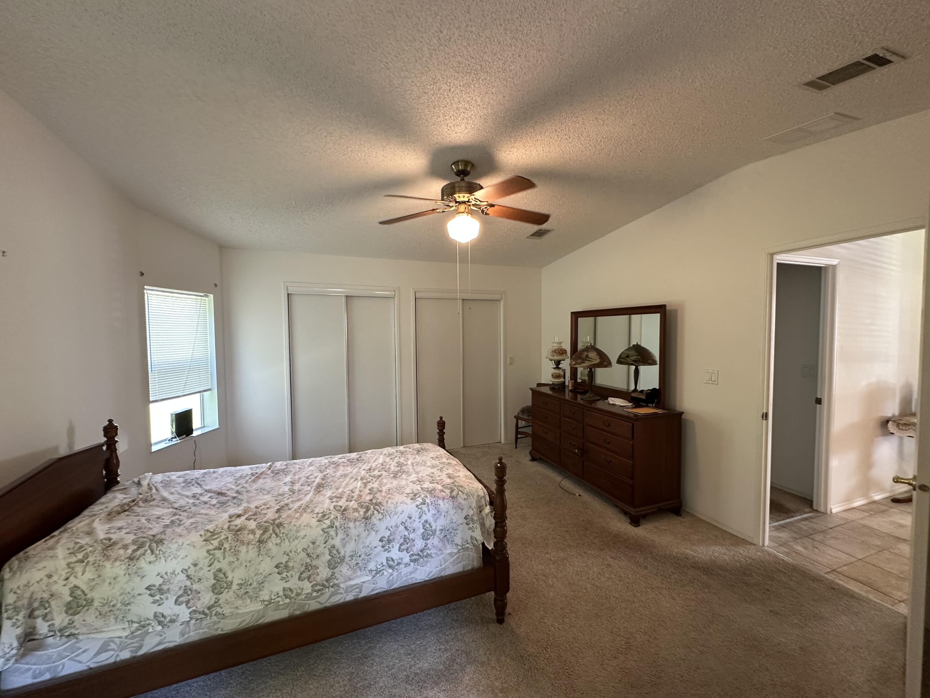 302 Tropical Isles Circle Fort Pierce, FL 34982 - Photo 18 of 22 a bedroom with a bed and a chandelier