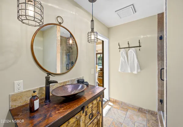 a bathroom with a sink a mirror and a shower