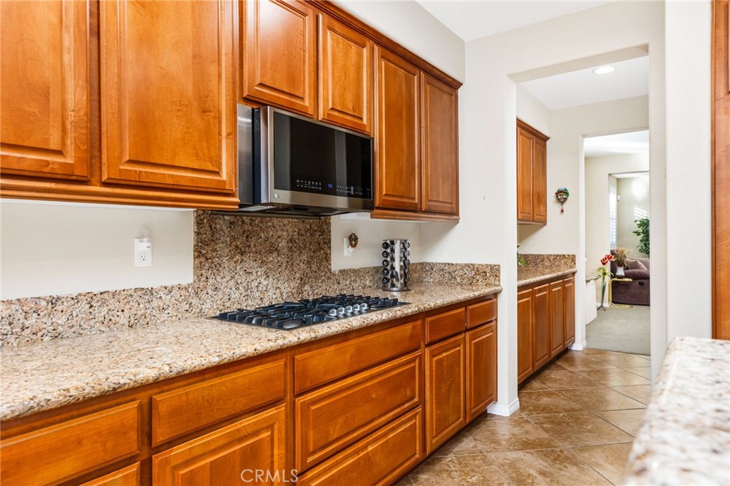 34641 Irwin Street Beaumont, CA 92223 - Photo 20 of 63 a kitchen with stainless steel appliances granite countertop a stove a sink and a microwave