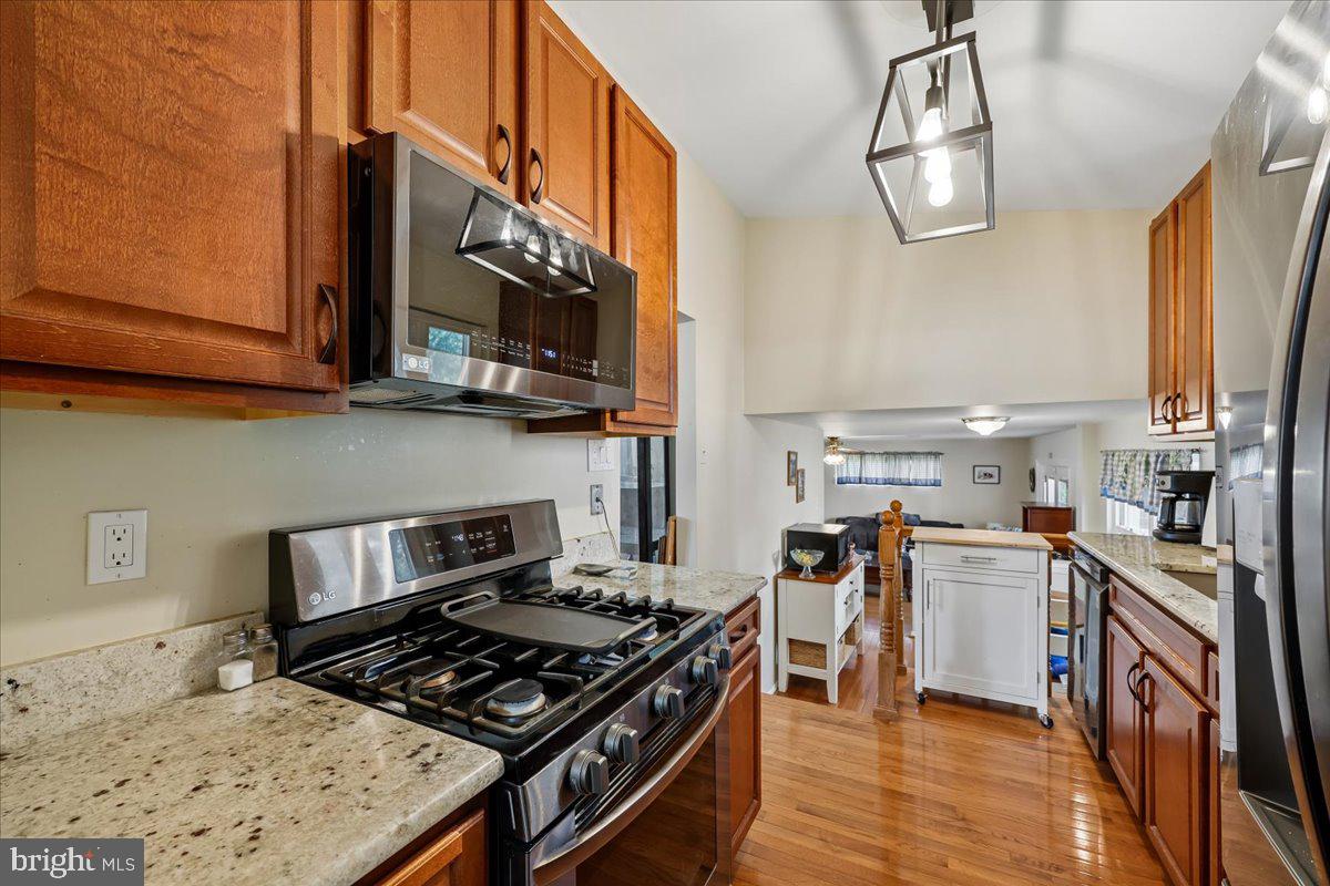 5001 Aspen Hill Road Rockville, MD 20853 - Photo 18 of 68 a kitchen with stainless steel appliances granite countertop a stove top oven a sink dishwasher and cabinets with wooden floor