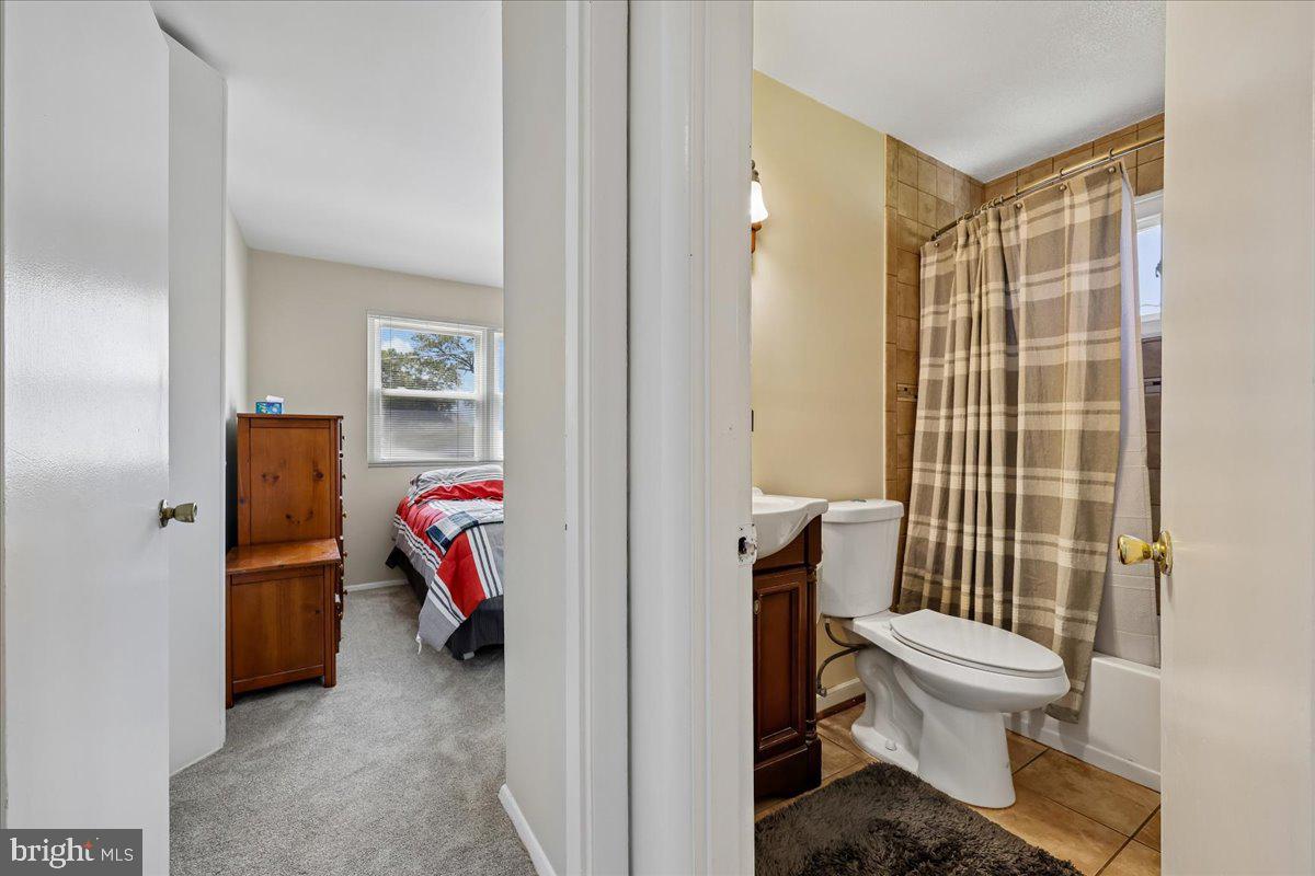 5001 Aspen Hill Road Rockville, MD 20853 - Photo 46 of 68 a bathroom with a toilet and a shower curtain