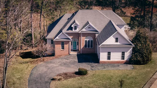 a view of a house with a yard and large tree