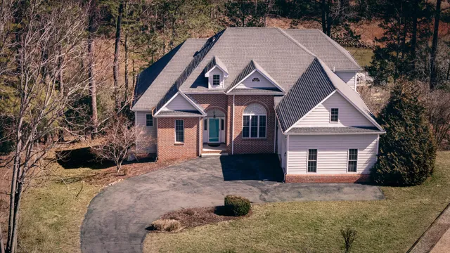 a view of a house with a yard and large tree