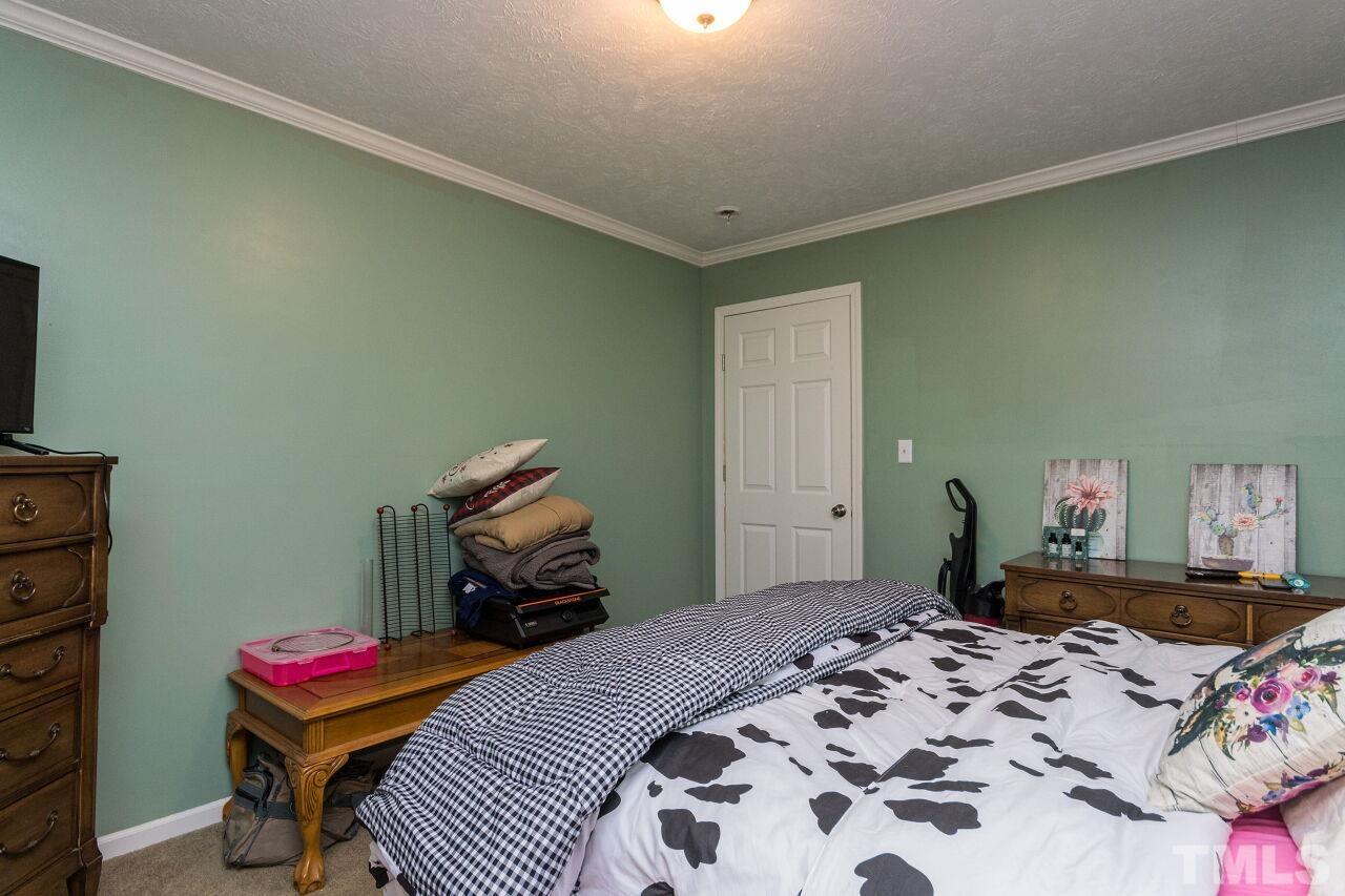 175 Williams Road Spring Hope, NC 27882 - Photo 21 of 30 a bedroom with a bed and wooden floor