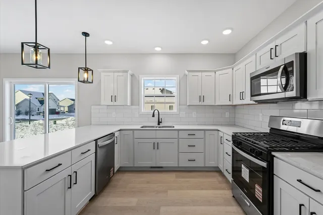a kitchen with stainless steel appliances granite countertop a sink stove and microwave