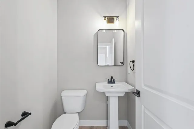 a bathroom with a toilet sink and mirror