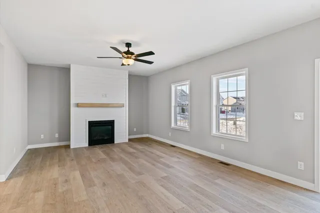 a view of an empty room with a fireplace and a window