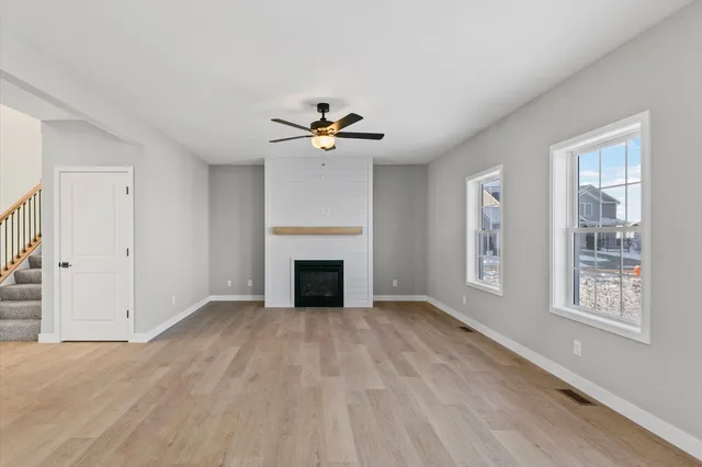 a view of an empty room with a fireplace and a window
