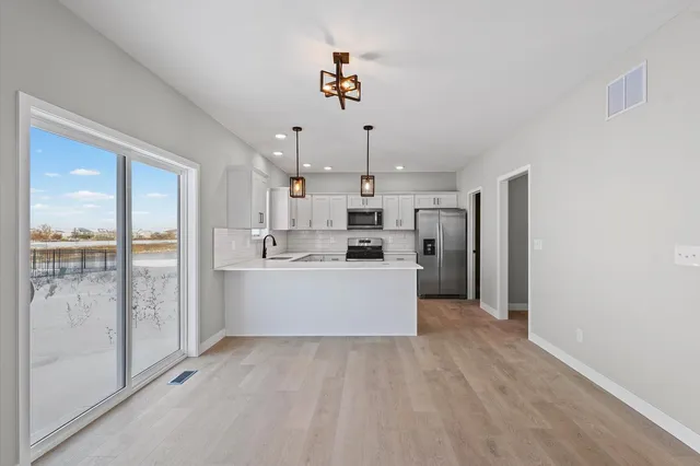 a view of a kitchen with a sink and refrigerator