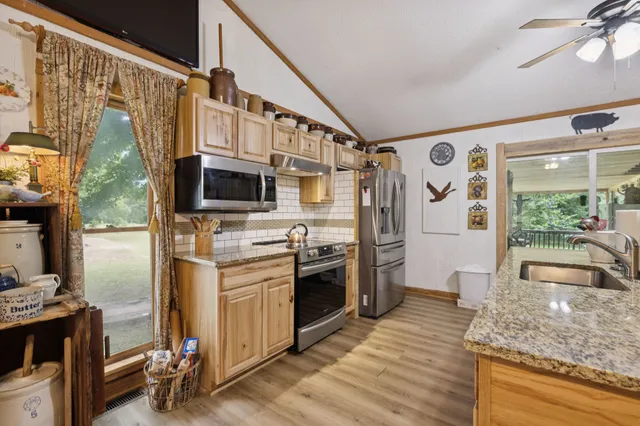 a kitchen with stainless steel appliances granite countertop a sink and stove