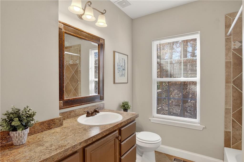 3016 Pathway Road Gainesville, GA 30501 - Photo 24 of 44 a bathroom with a granite countertop sink a toilet and a mirror