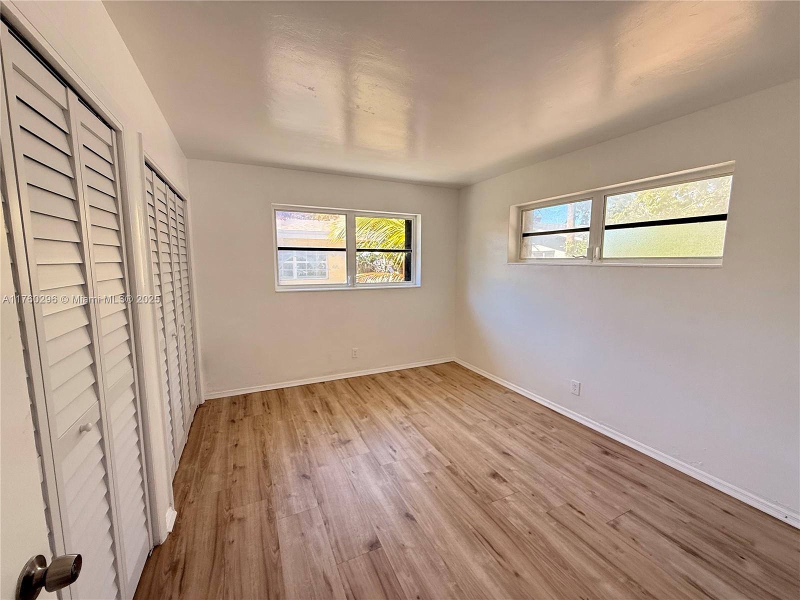 801 Southwest 7th Street, Unit B Pompano Beach, FL 33060 - Photo 14 of 20 an empty room with wooden floor and windows