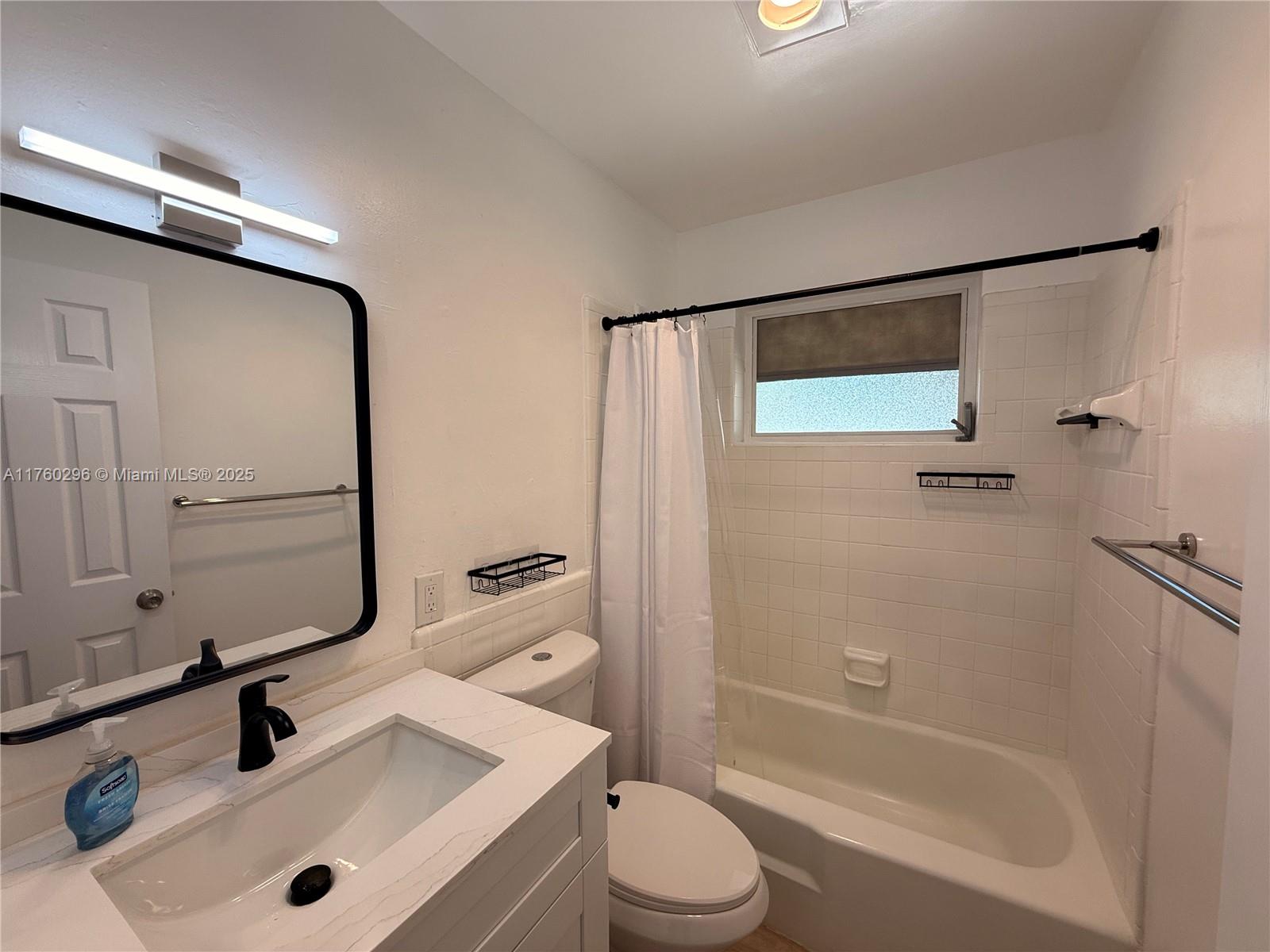 801 Southwest 7th Street, Unit B Pompano Beach, FL 33060 - Photo 17 of 20 a bathroom with a sink mirror vanity and toilet
