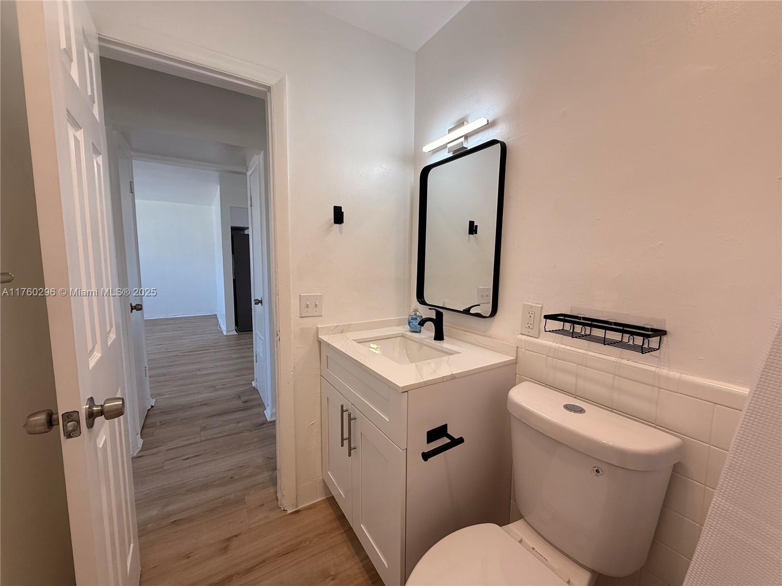 801 Southwest 7th Street, Unit B Pompano Beach, FL 33060 - Photo 19 of 20 a bathroom with a toilet sink and mirror