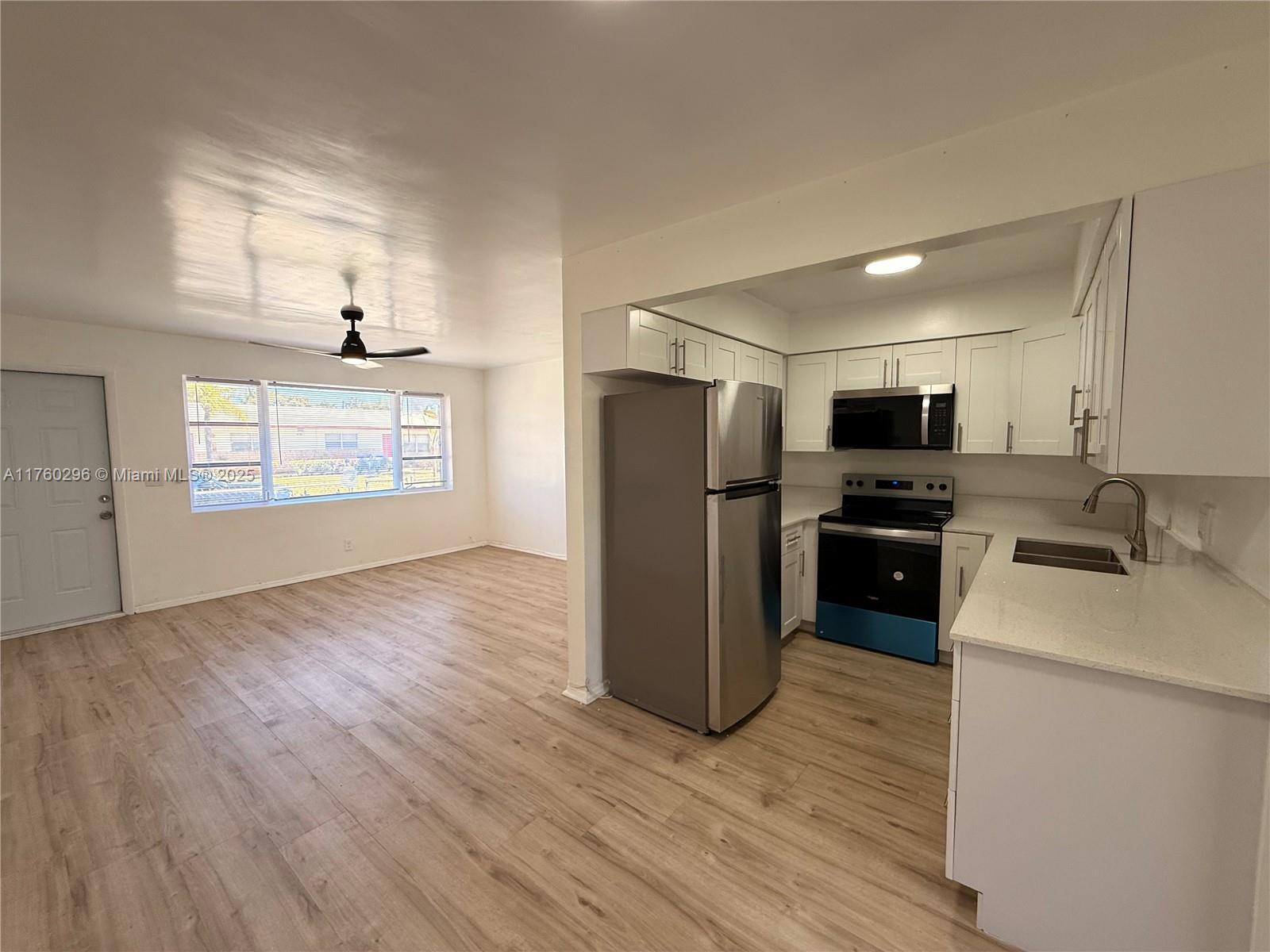 801 Southwest 7th Street, Unit B Pompano Beach, FL 33060 - Photo 3 of 20 a kitchen with stainless steel appliances a refrigerator stove and microwave