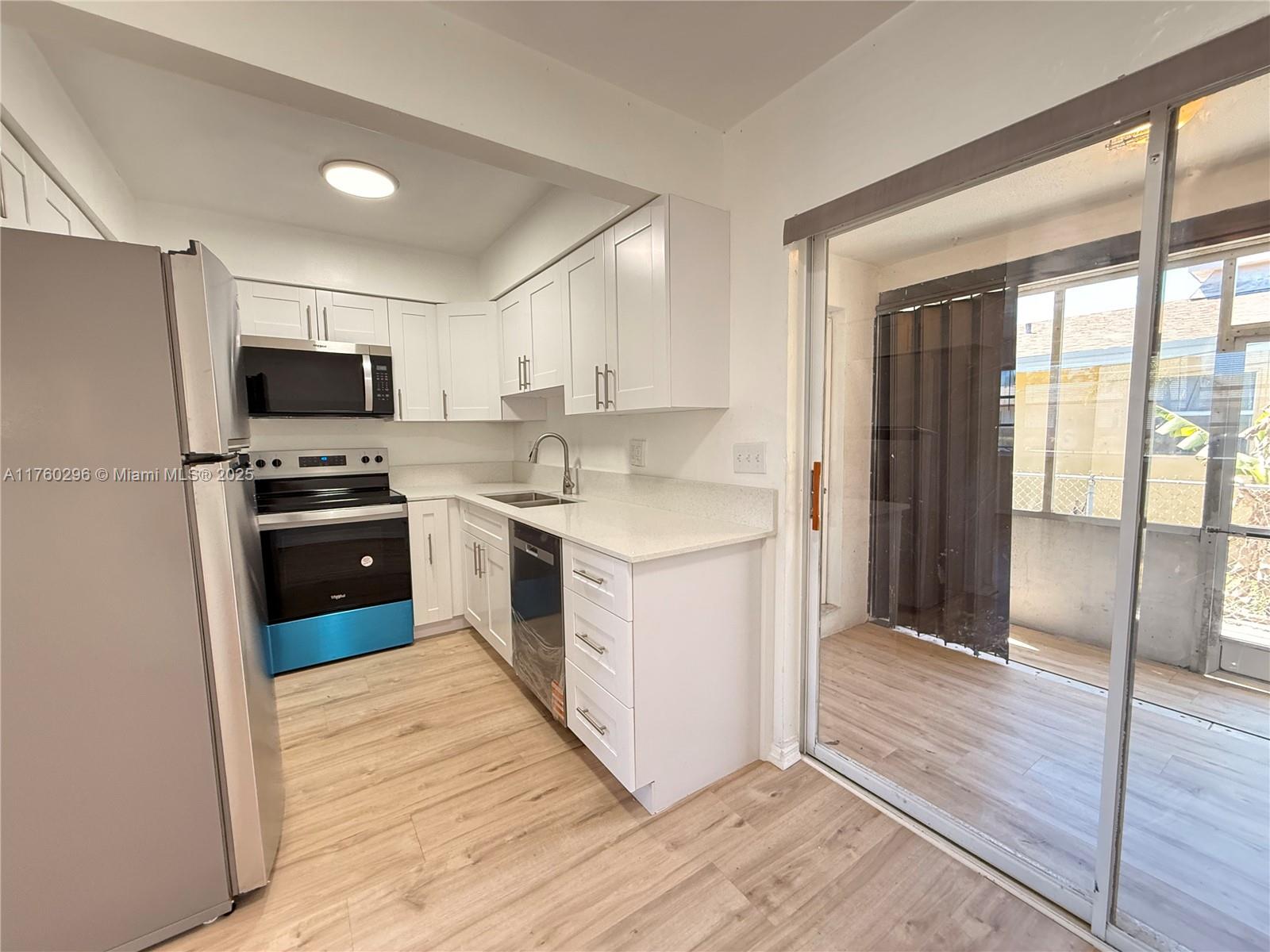 801 Southwest 7th Street, Unit B Pompano Beach, FL 33060 - Photo 4 of 20 a kitchen with a stove a sink and a refrigerator