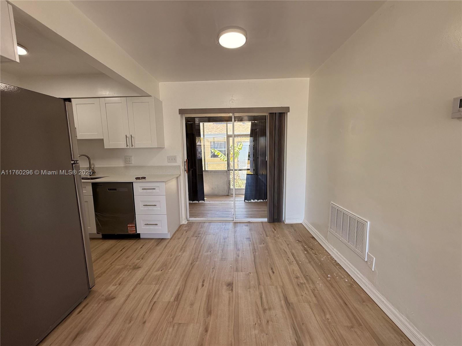 801 Southwest 7th Street, Unit B Pompano Beach, FL 33060 - Photo 6 of 20 a view of a kitchen with wooden floor and a window