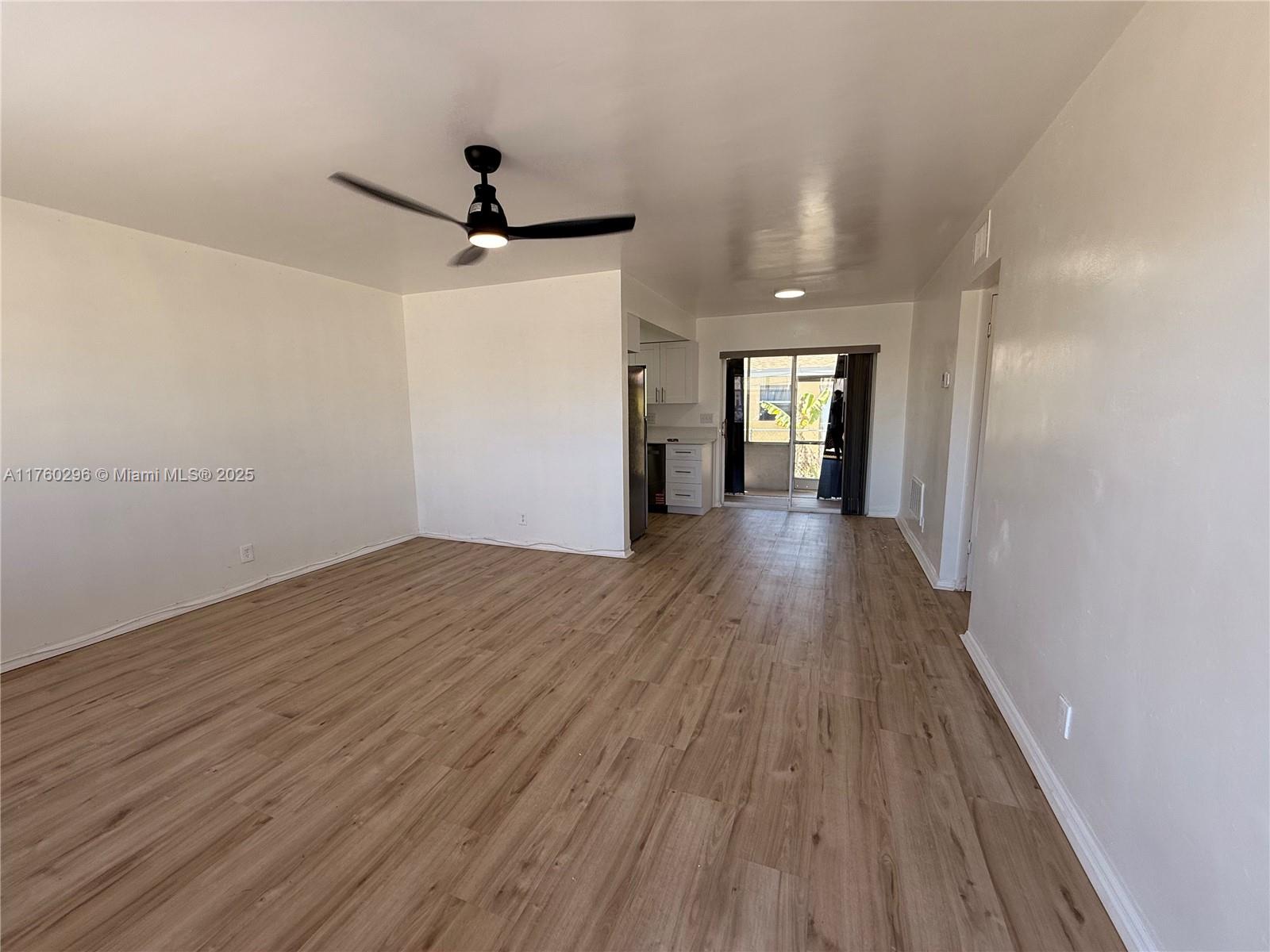 801 Southwest 7th Street, Unit B Pompano Beach, FL 33060 - Photo 8 of 20 a view of a room with wooden floor a ceiling fan and windows