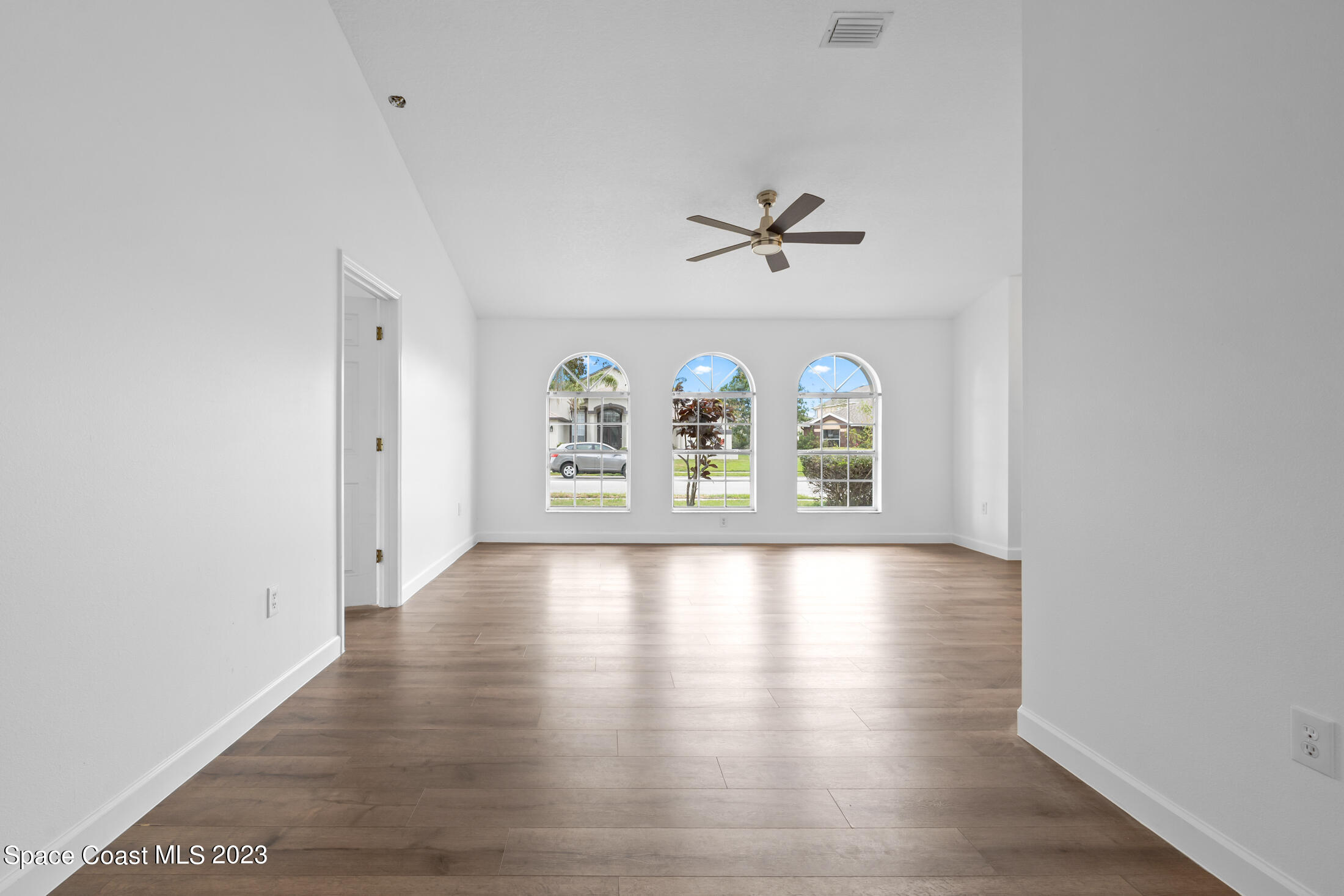 1940 Slone Boulevard Melbourne, FL 32935 - Photo 3 of 27 an empty room with windows and ceiling fan