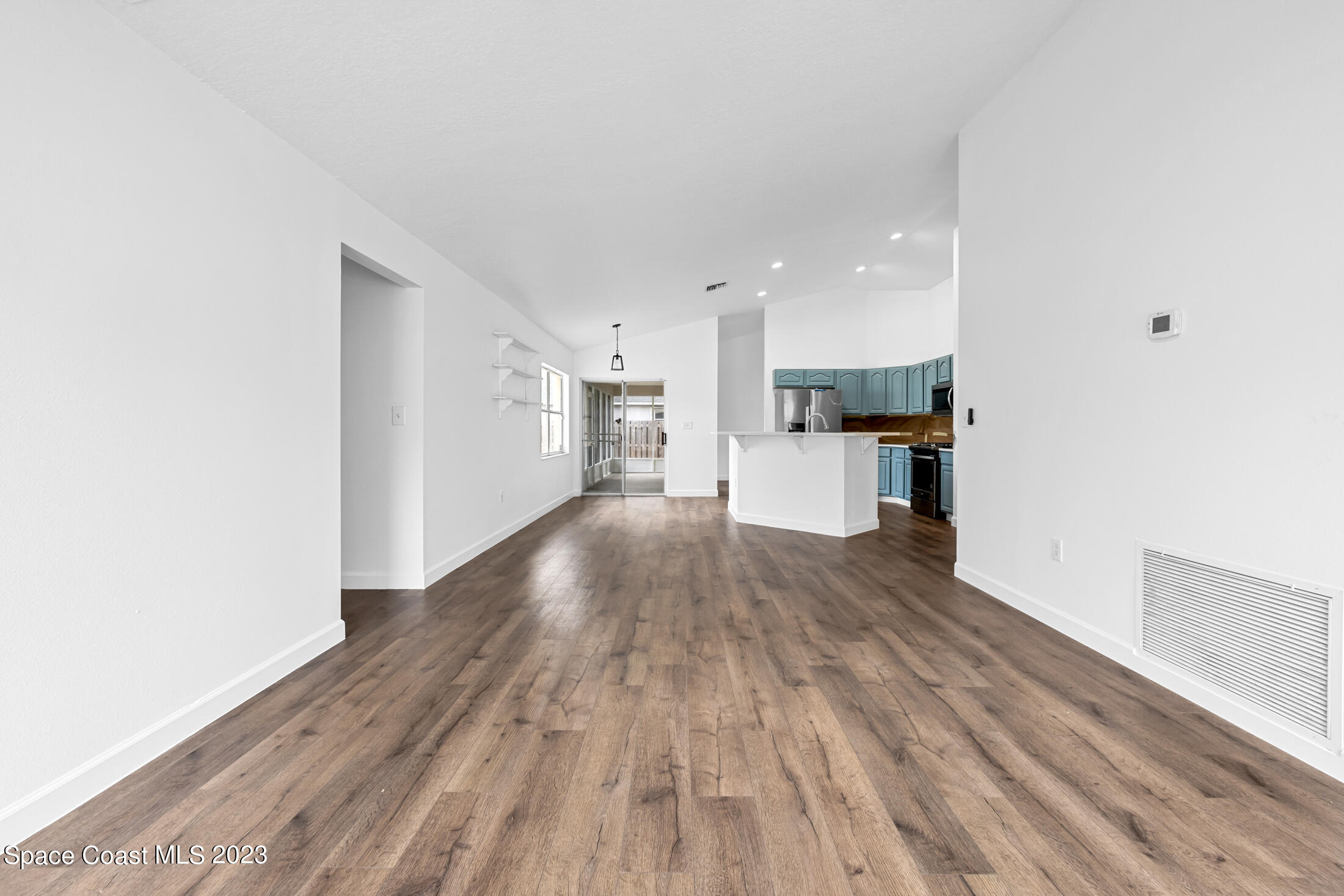1940 Slone Boulevard Melbourne, FL 32935 - Photo 8 of 27 a view of a kitchen with a fridge and wooden floor