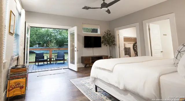 a spacious bedroom with a bed and a television