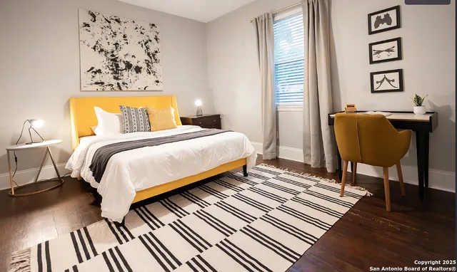 a bedroom with bed and wooden floor