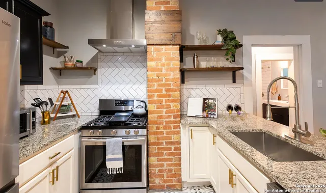 a kitchen with granite countertop a stove sink and cabinets