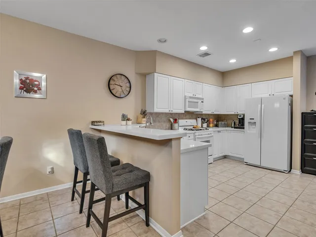 a kitchen with granite countertop white cabinets and white appliances