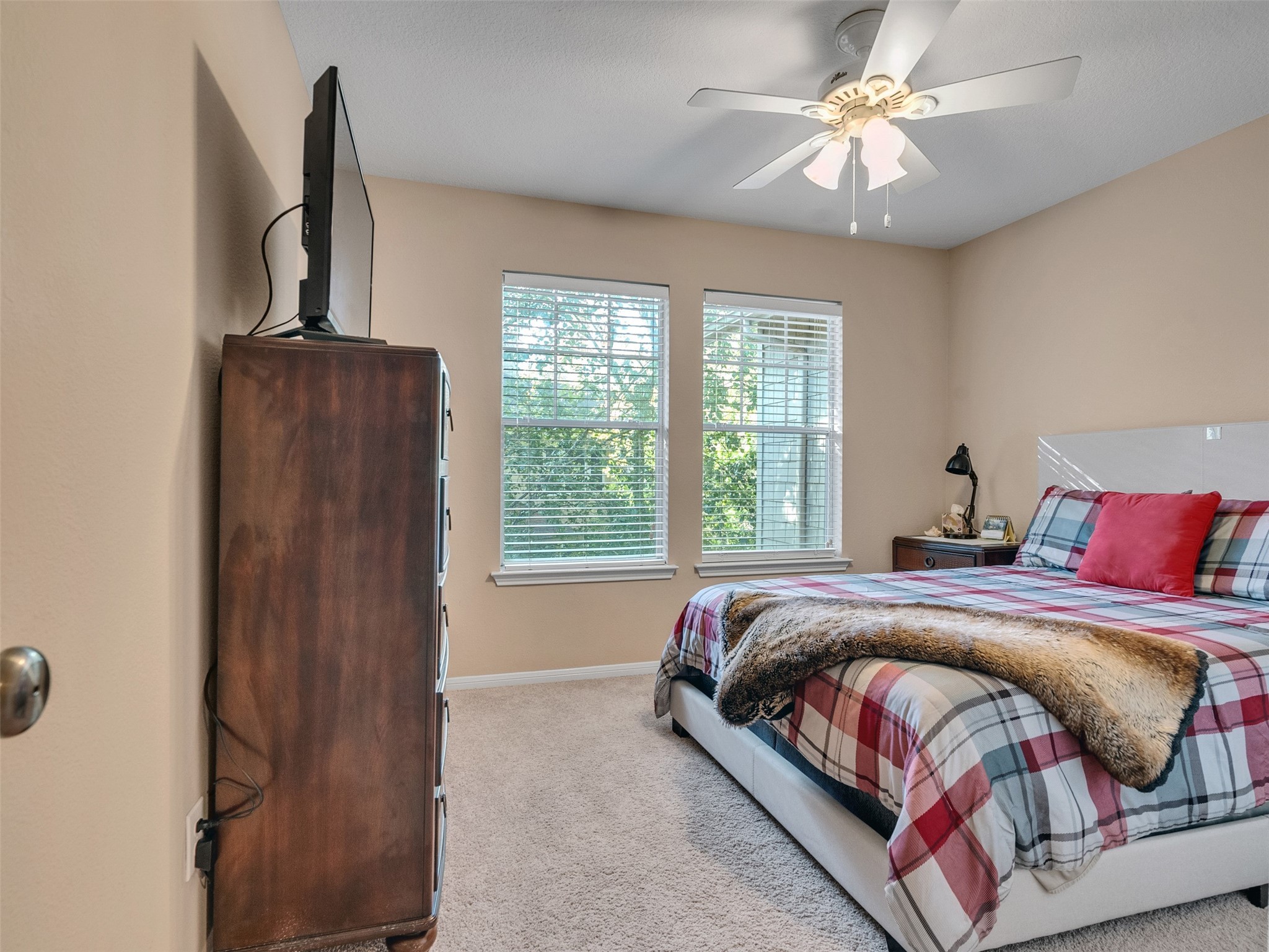 83 Scarlet Woods Court, Unit 83 The Woodlands, TX 77380 - Photo 23 of 34 Bedroom 3 has the third TV and a serene view of the trees out back.