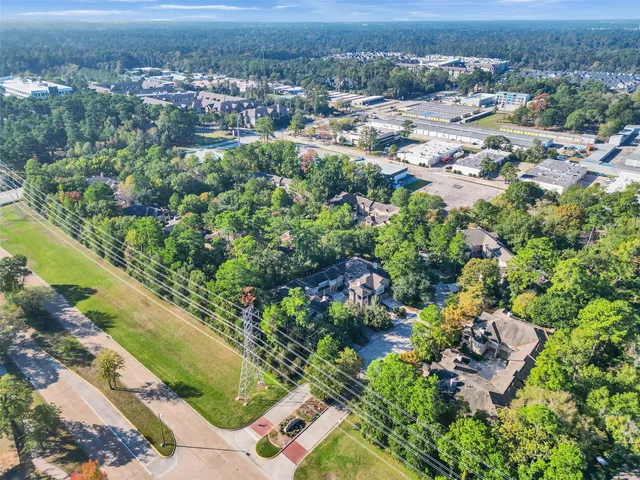 an aerial view of residential houses with outdoor space and trees